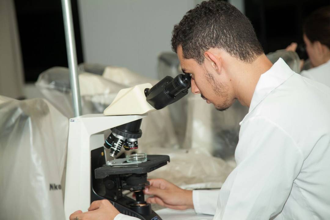 Bruno utiliza microscópio em laboratório